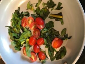 Fresh herbs, tomatoes, and chard ready to be added to a scrambled egg dish at Canterbury Center B&B